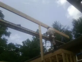 Carpenter setting a ridge beam over a new addition frame — Ice Dam Removal by Roofing Brothers in Kerhonkson