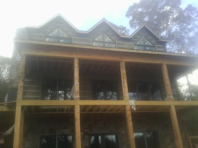 Dormers and porch framing on a large log home under construction — Roof Coating work by our crew in Kerhonkson