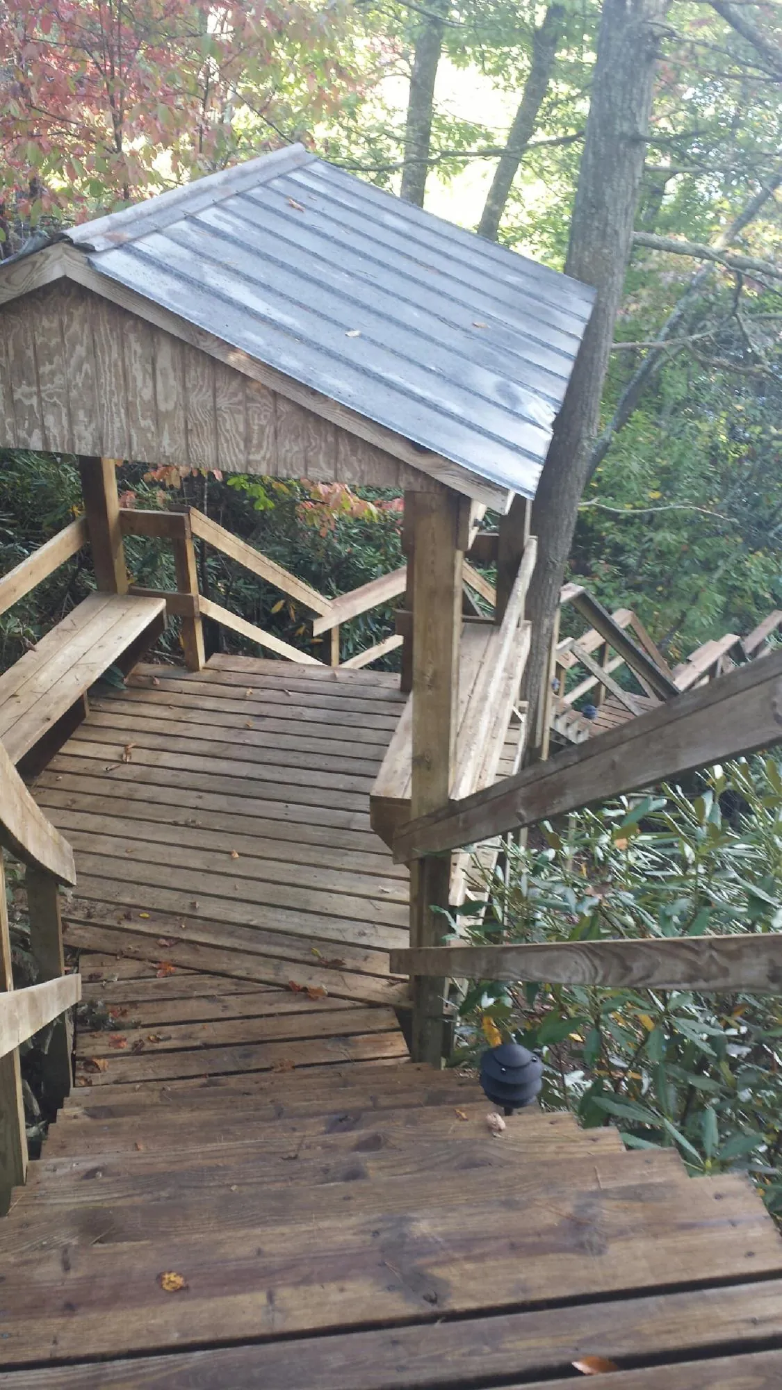 Metal roofed shelter over wooden steps on a wooded walkway — Skylight Repair & Installation work by our crew in Kerhonkson